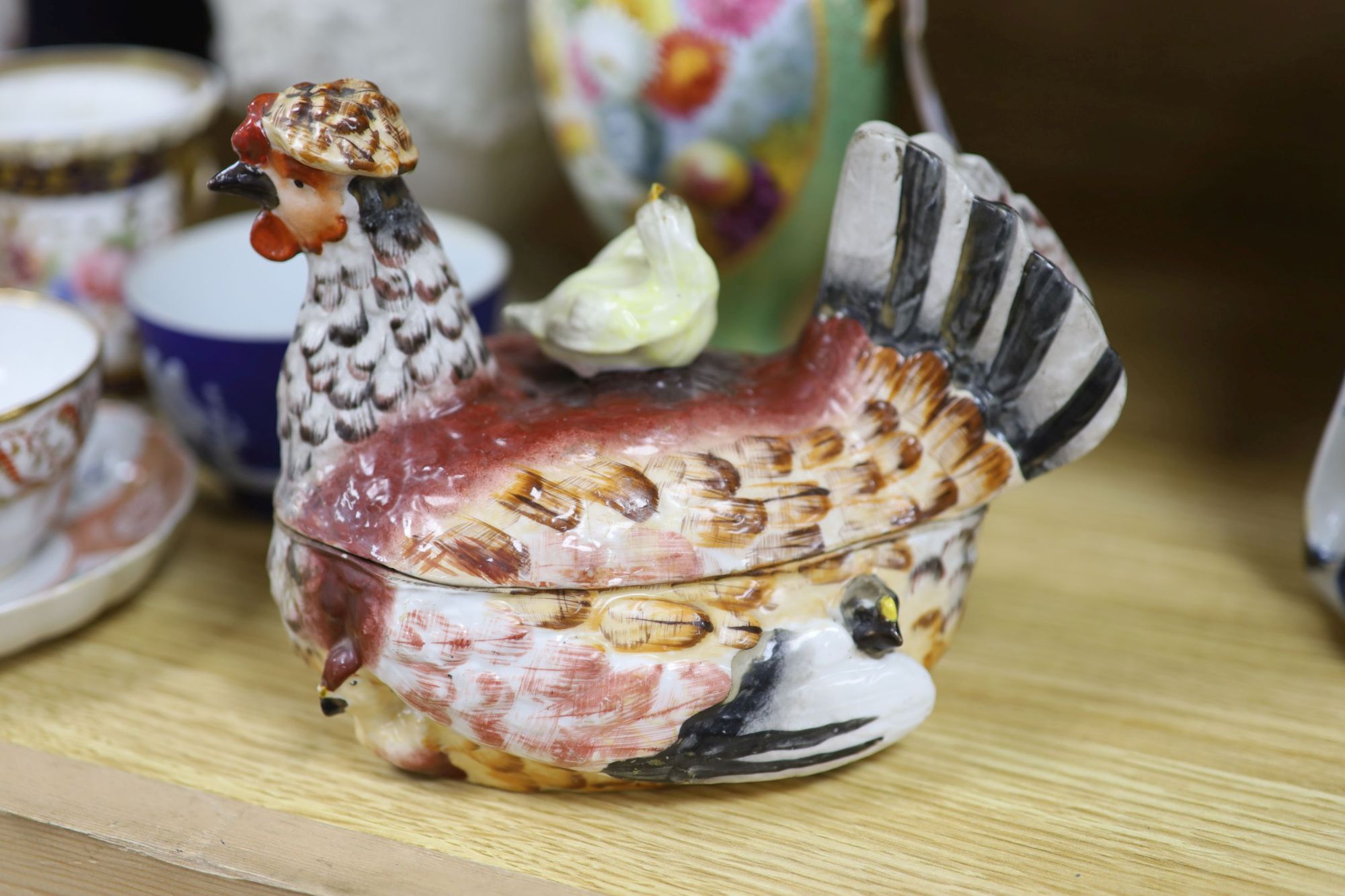 A group of mixed ceramics including a Copeland flower-painted vase, a Staffordshire hen and chick tureen and cover, Staffordshire cot